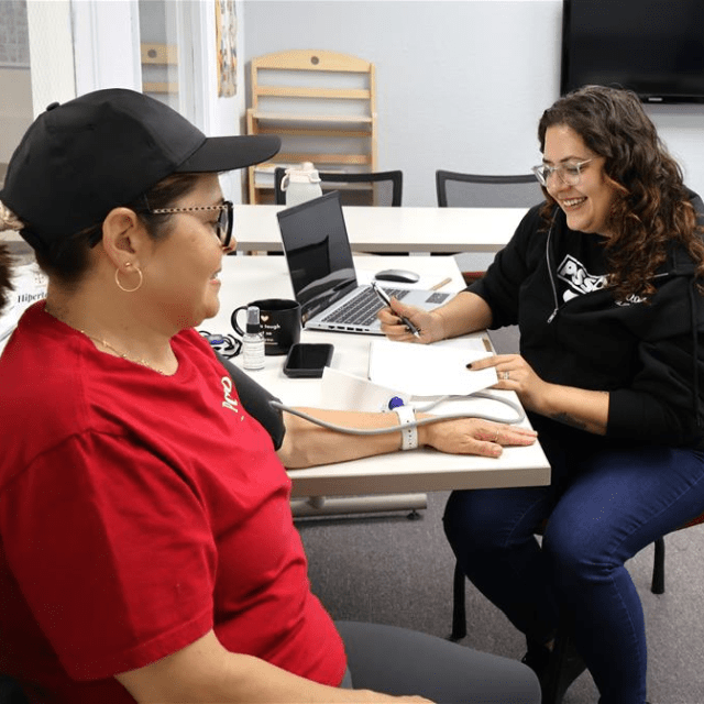 posso staff member taking client's blood pressure