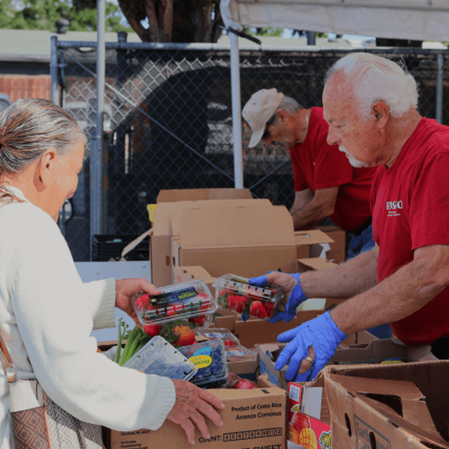 free groceries program volunteers providing a food box to a client